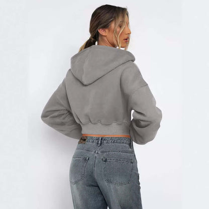 Woman wearing a casual grey long sleeved fleece zipper hoodie, showcasing the back design and relaxed fit.