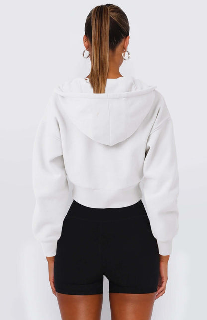 Back view of a woman wearing a casual white cropped fleece zipper hoodie with black shorts, perfect for spring and fall.